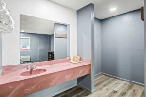 Vanity unit, mirror, wall shelf with towels, laminate flooring