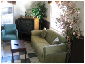 Breakfast seating area with sofa, coffee table, easy chair, TV and tiled flooring