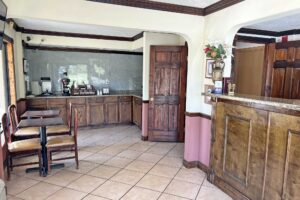 tables and chairs, breakfast display counter with coffeemaker and toaster, guest check in desk, tiled flooring