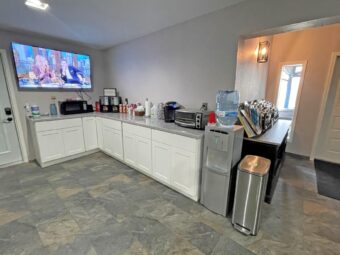 Wall mounted TV,breakfast display area with microwave, coffe machine, small oven, water dispenser, garbage bin, unit with guest information leaflet stand, tiled flooring
