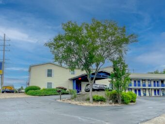 Brand signage, canopied drive through hotel entrance, two story building with covered walkways and exterior guest room entrances