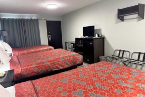 Double beds, desk with chair, wooden unit with TV, Fridge and microwave, portable folding luggage racks, hanging rail, laminate flooring