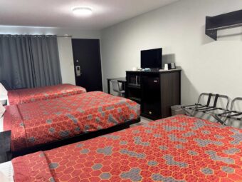 Double beds, desk with chair, wooden unit with TV, Fridge and microwave, portable folding luggage racks, hanging rail, laminate flooring