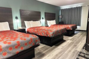 Three double beds, night stands with telephone, bedside lights, easy chair, floor lamp, portable folding luggage racks, laminate flooring