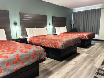 Three double beds, night stands with telephone, bedside lights, easy chair, floor lamp, portable folding luggage racks, laminate flooring