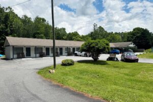 One story building with exterior guest room entrances, parking spaces, hotel entrance