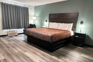 King bed, easy chair, night stands with telephone, bedside lights, laminate flooring