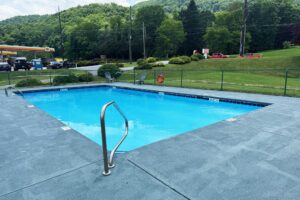 Outdoor pool, concrete surround and safety fence, pool chairs