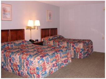 Two double beds, night stand with telephone, wall mounted bedside lights and art, carpet flooring