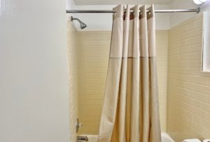 Shower tub with tiled surround and shower curtain
