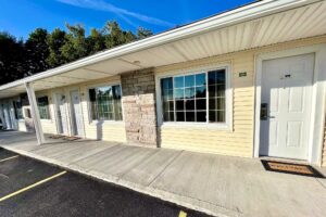 Exterior entrances to guest rooms, covered walkway, parking spaces