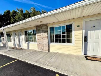 Exterior entrances to guest rooms, covered walkway, parking spaces