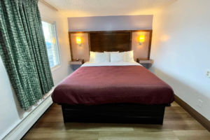 King bed, wall lights and bedside shelves, laminate flooring