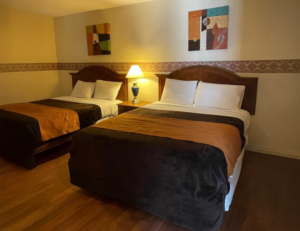 Two queen beds, night stand with lamp, art images, laminate flooring