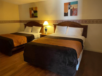 Two queen beds, night stand with lamp, art images, laminate flooring
