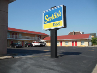 Brand signage, two story and single story building with covered walkways and exterior guest room entrances, parking spaces
