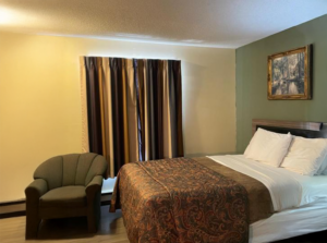 Queen bed, art image, armchair, laminate flooring