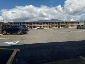 Two story building with exterior guest entrances, covered walkways and stairs, parking spaces