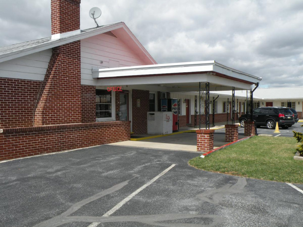 Hotel Entrance, canopy, ice machine, parking area, grassy area and bushes