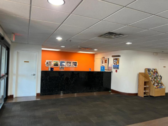 Guest check-in desk, guest information stand with leaflets, carpet flooring