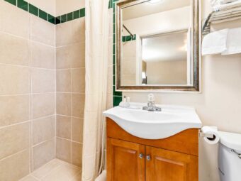 Shower with shower curtain, vanity unit, mirror, towel shelf and rail with towels