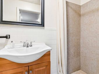Shower with shower curtain, vanity unit, mirror