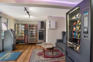 Vending machines with snacks and drinks, ATM, sofa, coffee table, laminate flooring and rugs