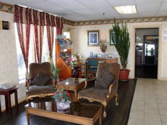 easy chairs, occasional tables, potted plants, desk with chair and computer, leaflet stand with guest activities information, tiled and laminate flooring, doorway to breakfast area