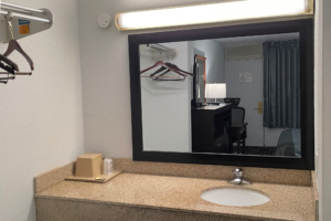 Vanity unit, ice bucket, mirror, overhead light, shelf with hanging rail and hangers