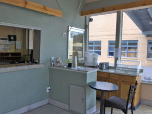 Guest check in desk, breakfast area, small table and chair, tiled flooring