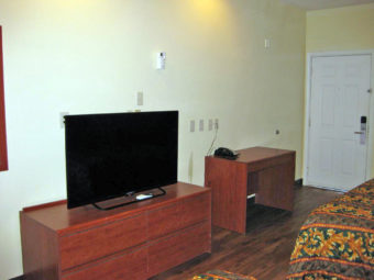 Two queen beds, wooden unit with flat screen tv, desk with telephone, laminate flooring