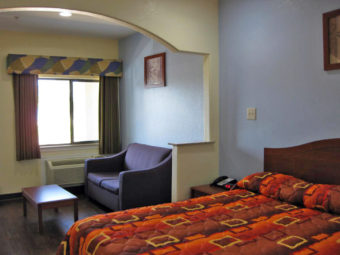 King bed, night stand with telephone and clock, sofa, coffee table, laminate flooring
