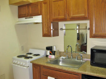 Stove, wall and base cabinets, countopr with sink, coffee maker, microwave