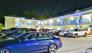 Two story building displayed at night with exterior room entrances, walkways and stairs, parking spaces