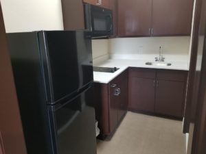 Full size fridge, microwave, hob, sink, wall and base cabinets