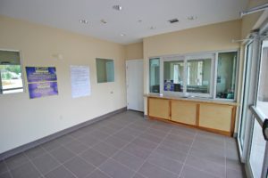 Guest check in desk, protective glass partition, tiled flooring