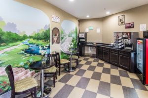 Breakfast counter display with coffee machine, juice dispenser, chilled cabinet, slamm tables and chairs, tiled flooring