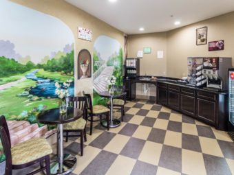 Breakfast counter display with coffee machine, juice dispenser, chilled cabinet, slamm tables and chairs, tiled flooring