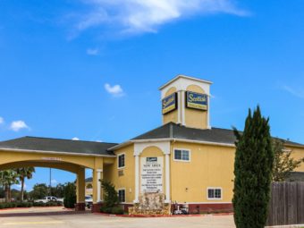 Hotel entrance with drive through canopy, two story building, landscaping with trees and shrubs