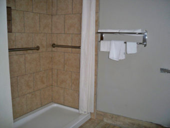 Walk in Shower, wll mounted towel rail with towels, tiled flooring