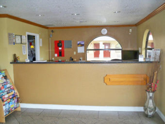 Guest check in desk, guest information leaflet stand, tiled flooring