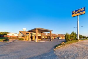 Brand signage, drive through canopy, hotel entrance, external entrances to guest rooms, parking spaces, landscaping with grassy areas and small bushes
