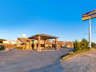 Brand signage, drive through canopy, hotel entrance, external entrances to guest rooms, parking spaces, landscaping with grassy areas and small bushes