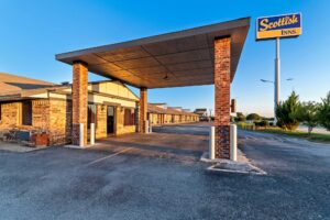 Brand signage, drive through canopy, hotel entrance, external entrances to guest rooms, parking spaces, landscaping with grassy areas and small bushes