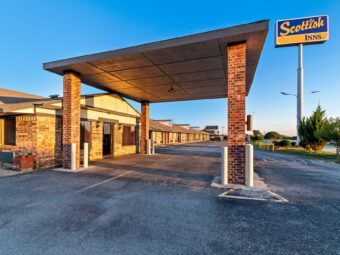 Brand signage, drive through canopy, hotel entrance, external entrances to guest rooms, parking spaces, landscaping with grassy areas and small bushes