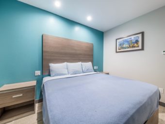 King bed, night stands with telephone, wall mounted art, laminate flooring