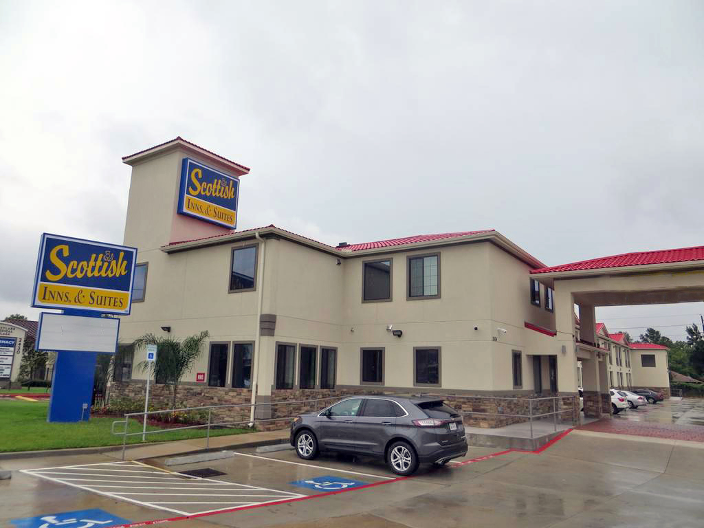 STXFR Exterior 100 Hotel entrance with drive through canopy, brand signage, two story building, parking spaces