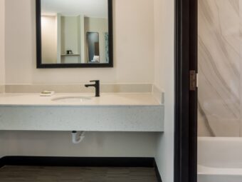 Vanity unit, mirror, doorway to shower tub