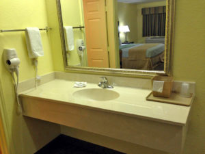 Vanity unit, wall mounted hair dryer, towel rail with towel, mirror