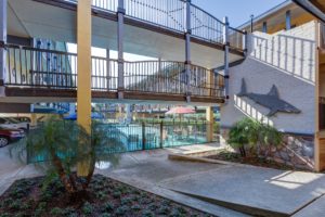 Two story buildings with walkways overlooking pool